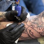 Tatoueur en train de faire un premier tatouage sur le bras d'un client